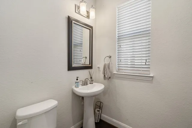 a bathroom with a sink a toilet and mirror