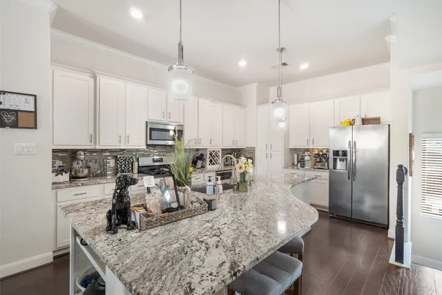 a kitchen with stainless steel appliances granite countertop a sink refrigerator and microwave