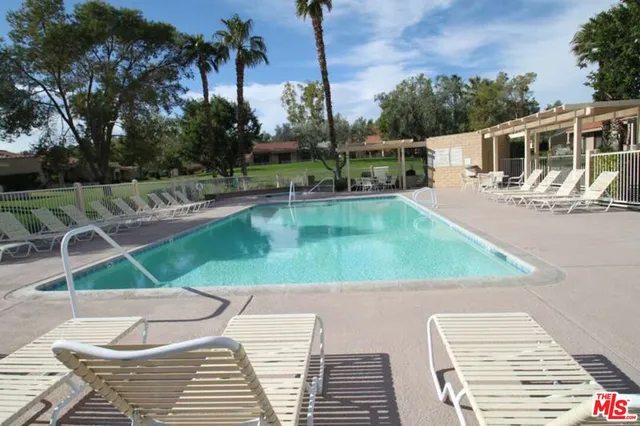 a view of a tennis ground with large trees
