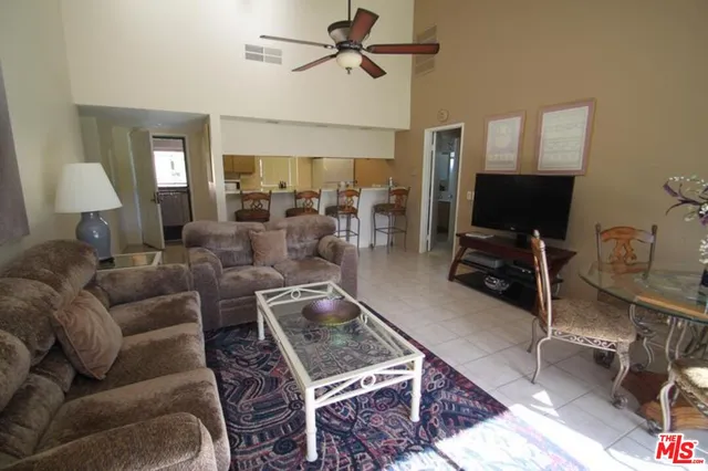 a living room with furniture a ceiling fan and a rug