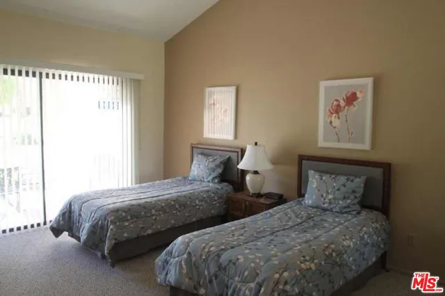 a bedroom with two beds and a large window