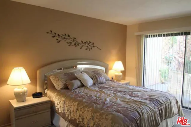 a bedroom with a bed and a lamp next to a window