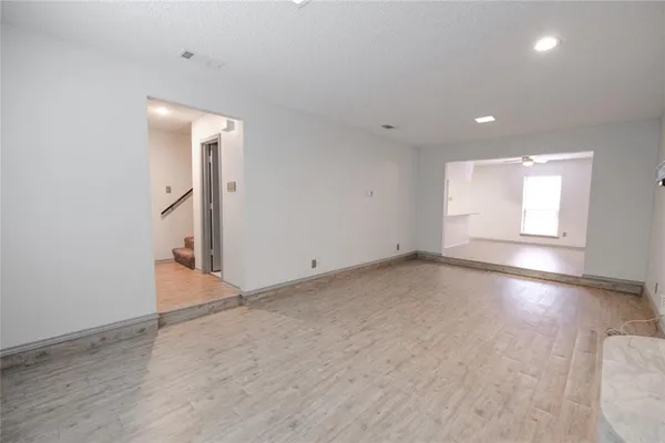 an empty room with a fireplace and wooden floor