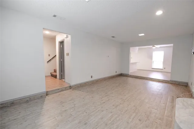 an empty room with a fireplace and wooden floor