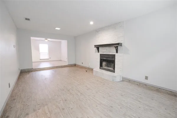 an empty room with a fireplace and windows