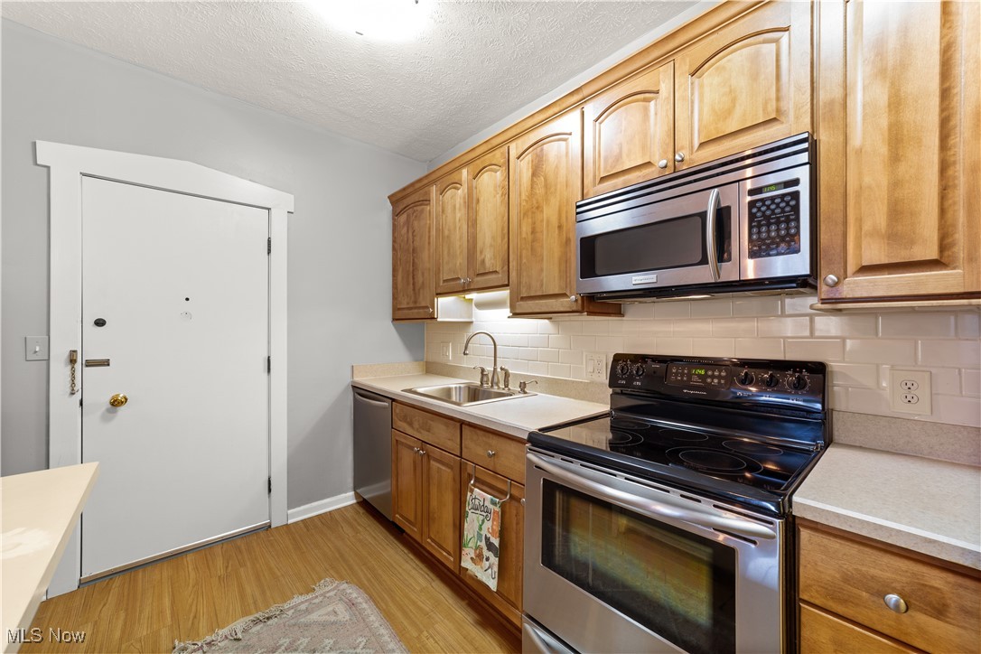 2472 Overlook Road, Unit 3 Cleveland, OH 44106 - Photo 7 of 11 Kitchen featuring appliances with stainless steel finishes, light countertops, light wood-style floors, and a sink