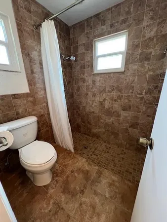 a bathroom with a toilet and a shower