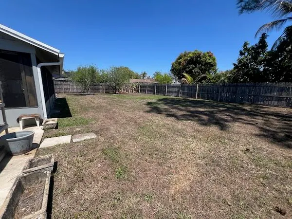a view of a backyard with wooden fence