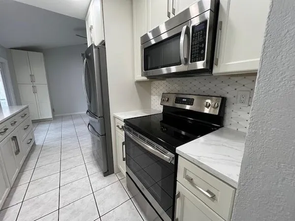 a kitchen with granite countertop a stove and a microwave
