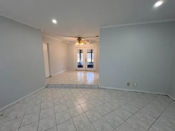 an empty room with entrance and windows