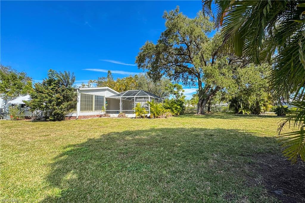 296 Riverwood Road Naples, FL 34114 - Photo 12 of 18 a front view of a house with a yard