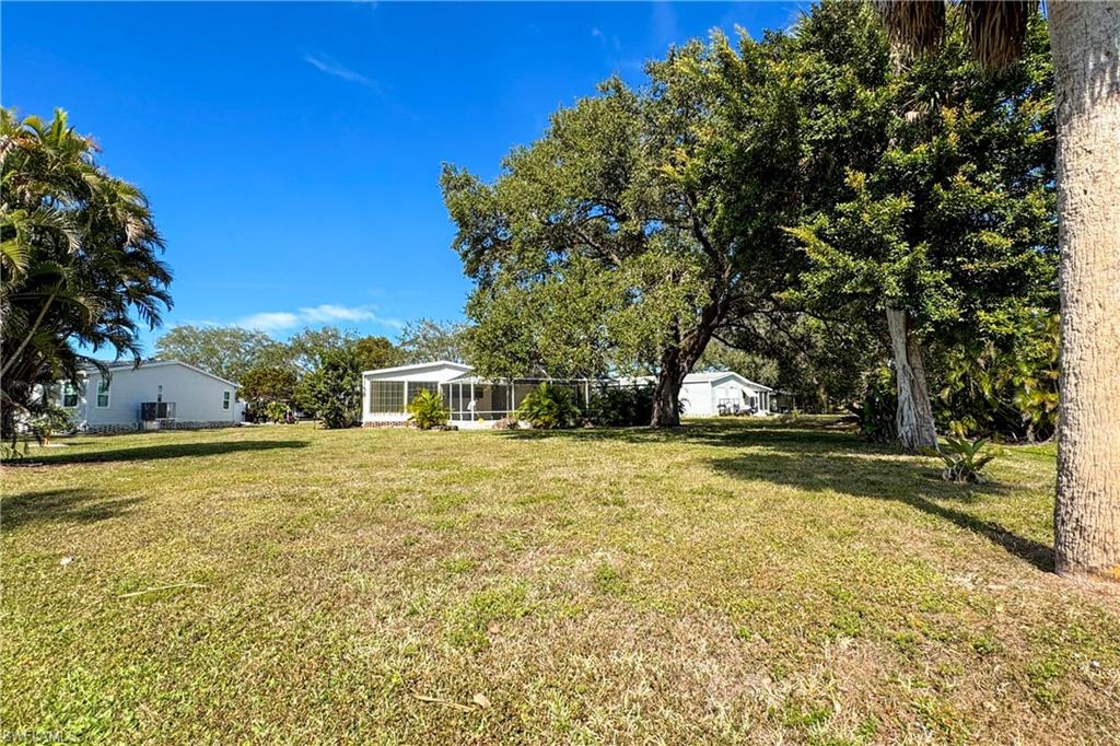 296 Riverwood Road Naples, FL 34114 - Photo 14 of 18 a yellow house with trees in front of it