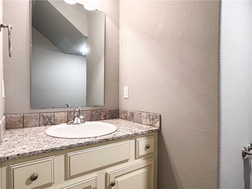 1275 North Rupple Road Fayetteville, AR 72704 - Photo 8 of 20 Bathroom vanity with light-toned cabinetry, a built-in sink, and a granite-style countertop