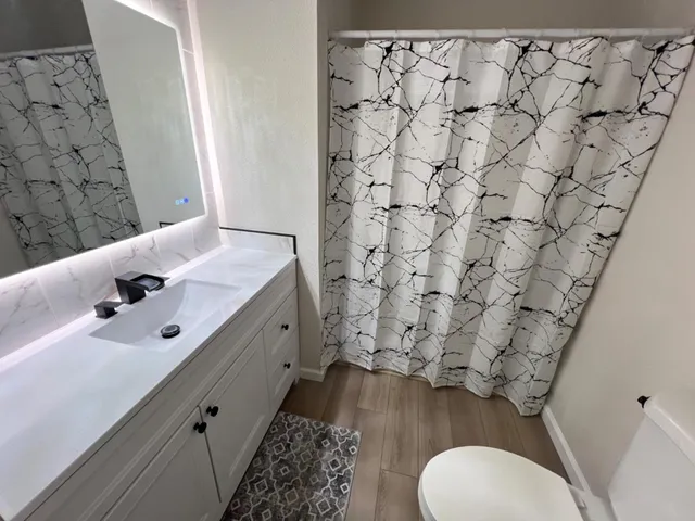 a bathroom with a sink toilet and shower