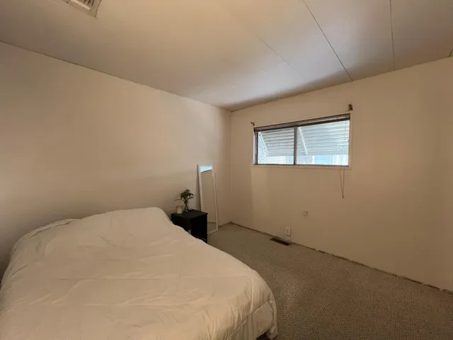 a bedroom with a bed and a night stand