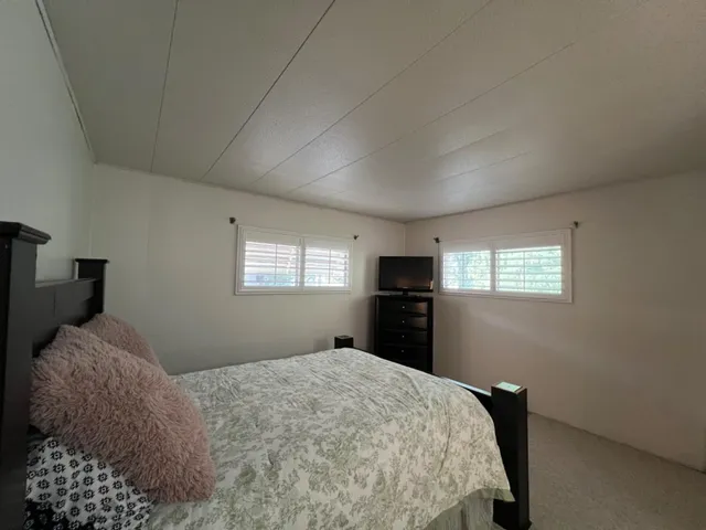 a bedroom with a bed and a television