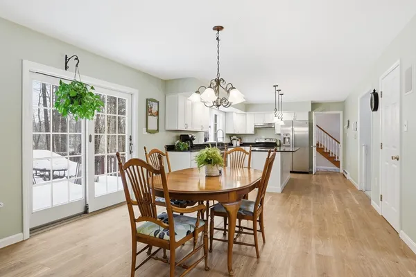 a dining room with furniture a chandelier and wooden floor
