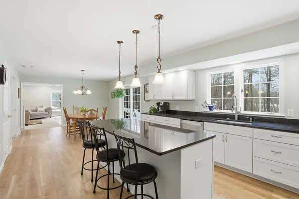 a kitchen with a table chairs and white cabinets