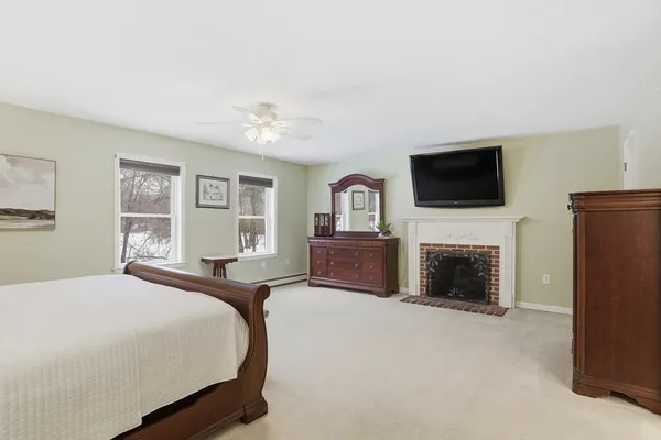 a spacious bedroom with a bed and a flat screen tv