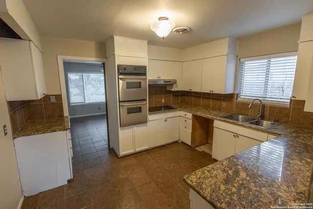 a view of a hallway with a chandelier fan and windows
