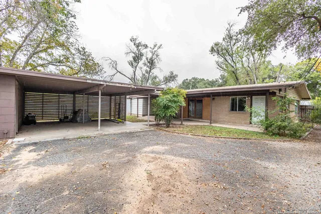 a view of a house with a yard and large tree