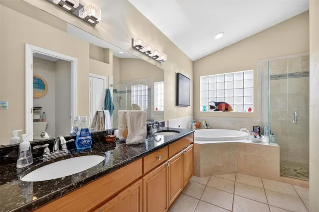 a large bathroom with a double vanity sink large mirror and a bathtub