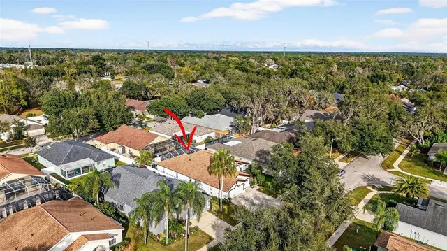 an aerial view of residential houses with outdoor space and trees