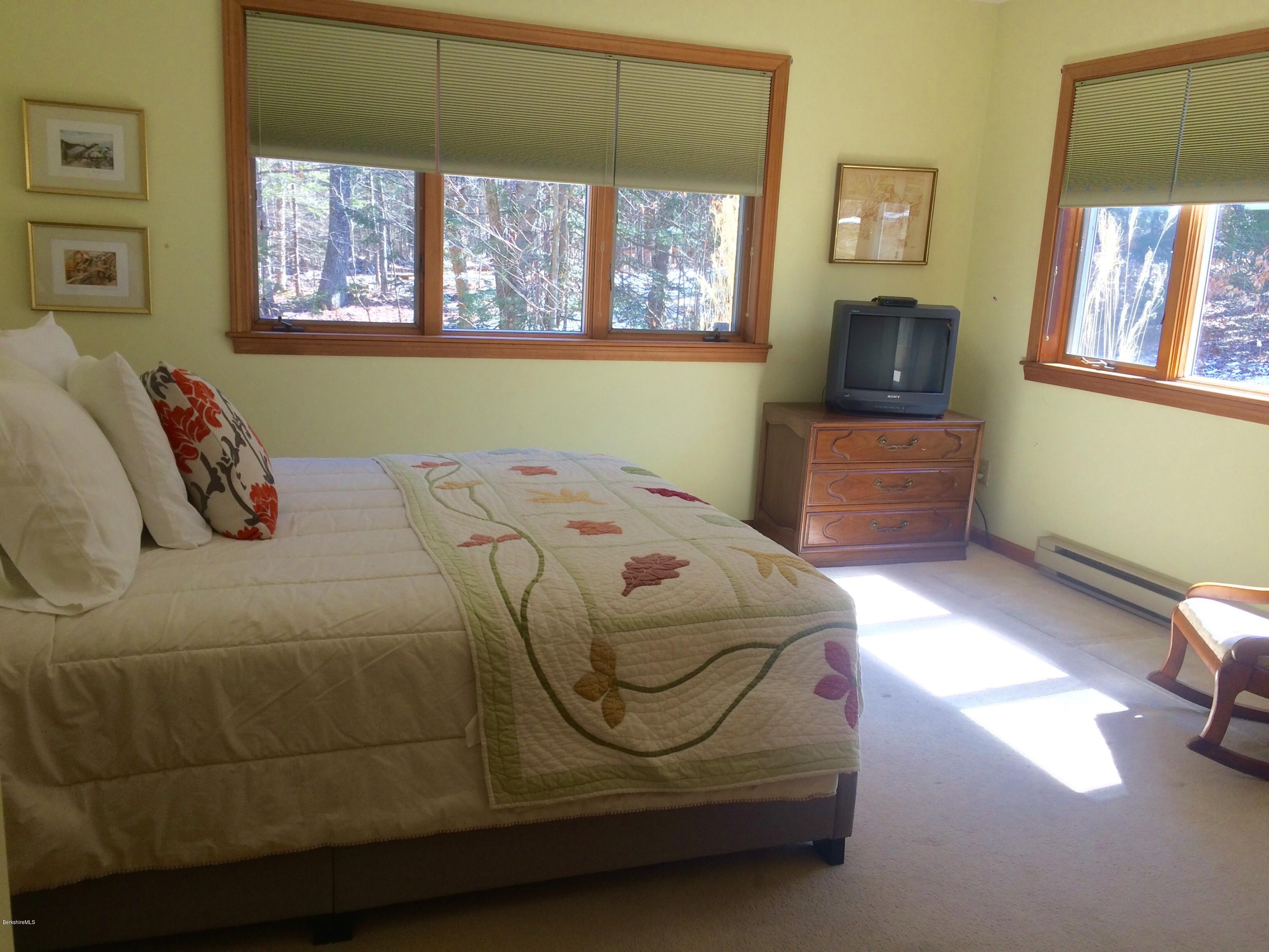 64 Monterey Road Tyringham, MA 01264 - Photo 16 of 26 a bedroom with a bed and a tv on table