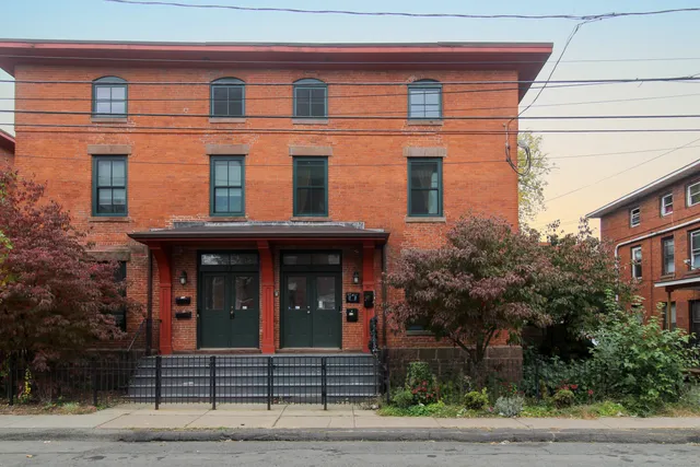 a view of a brick house with large windows