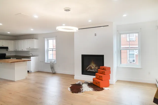 a living room with hard wood floors and a fireplace