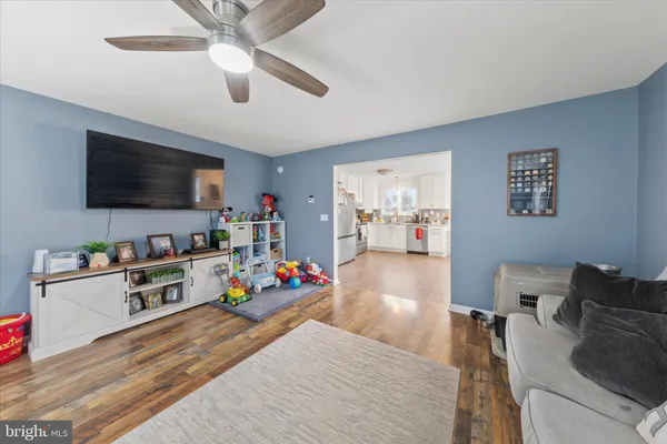 a kitchen with stainless steel appliances a stove a refrigerator a dining table and chairs with wooden floor