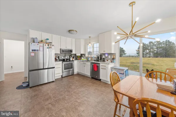 a kitchen with refrigerator cabinets table and chairs