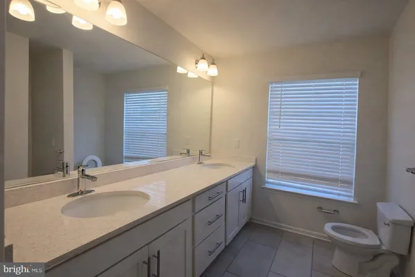 a bathroom with a granite countertop sink toilet a large mirror and a shower