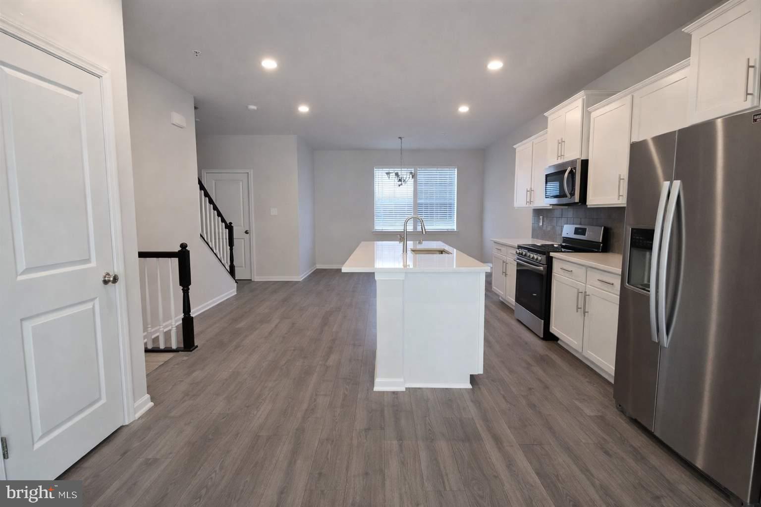 8706 Cherrybark Road Clinton, MD 20735 - Photo 4 of 21 a kitchen with kitchen island wooden floors appliances and sink
