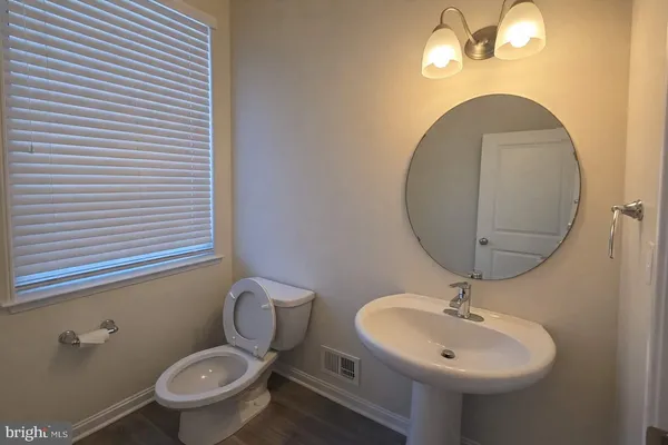 a bathroom with a toilet a sink and mirror