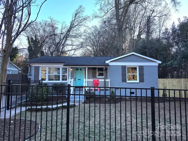 a view of a house with wooden deck and a trees