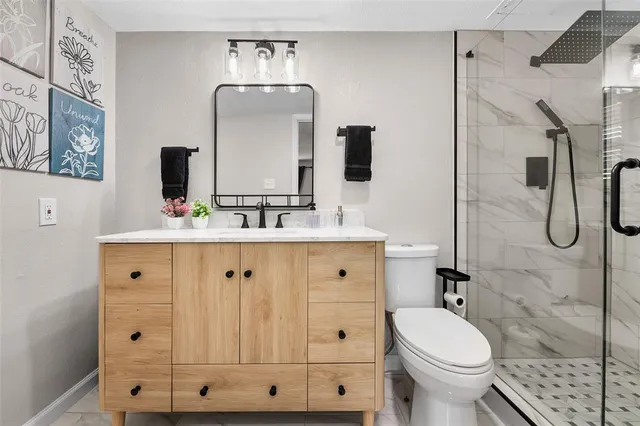 a bathroom with a double vanity sink toilet and shower
