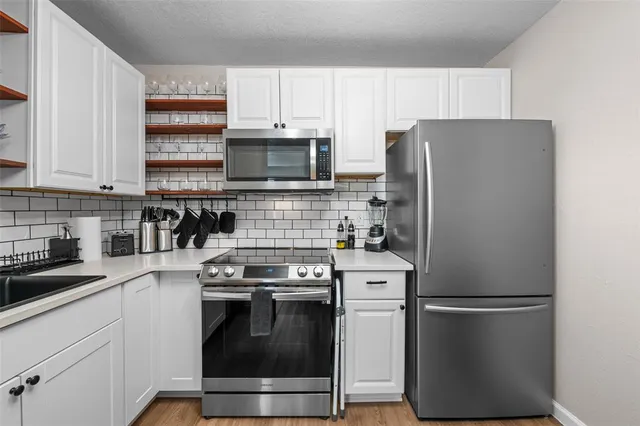 a kitchen with stainless steel appliances a refrigerator stove and microwave