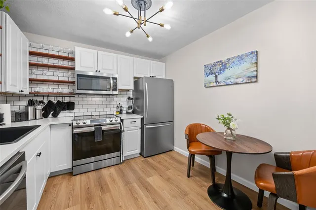 a kitchen with stainless steel appliances a stove a refrigerator and a refrigerator