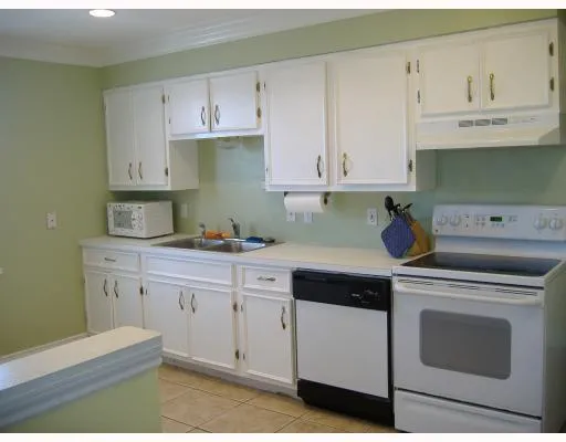 a kitchen with granite countertop white cabinets and white appliances