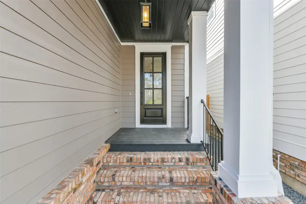a view of an empty room with a window and a kitchen