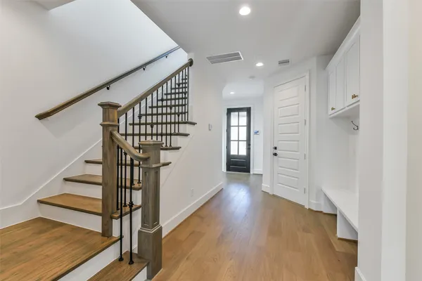 a large kitchen with a large counter top stainless steel appliances and wooden floor