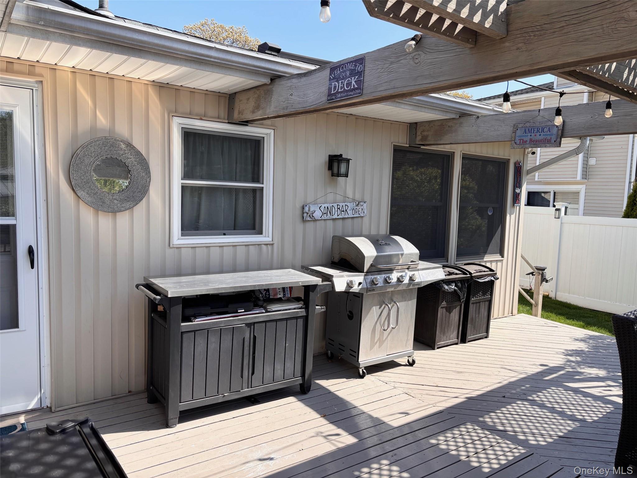 212 Matthews Road Oakdale, NY 11769 - Photo 29 of 38 Outdoor deck area featuring wood-finish flooring and a partial pergola structure