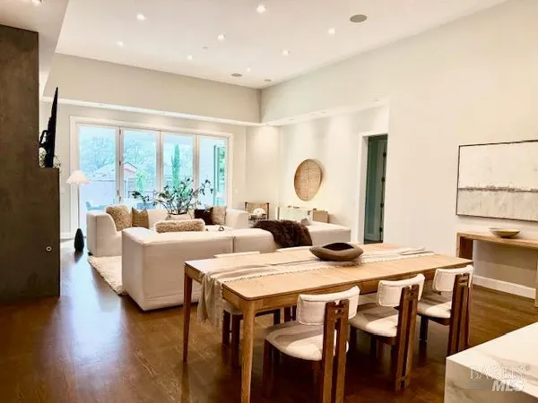 a dining room with furniture a large window and wooden floor