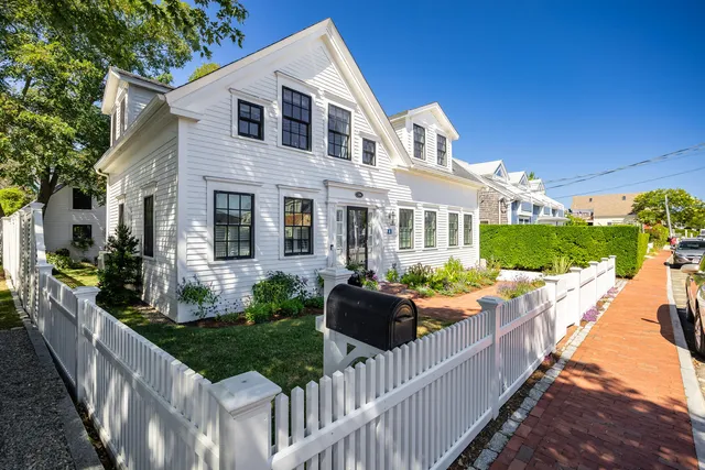 a front view of house and yard with wooden fence