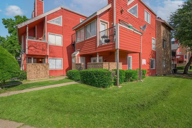a view of a brick building next to a big yard