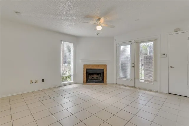 an empty room with windows and fireplace