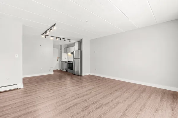 a view of empty room with wooden floor ceiling fan
