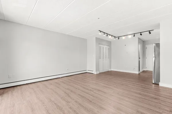 a view of an empty room with wooden floor