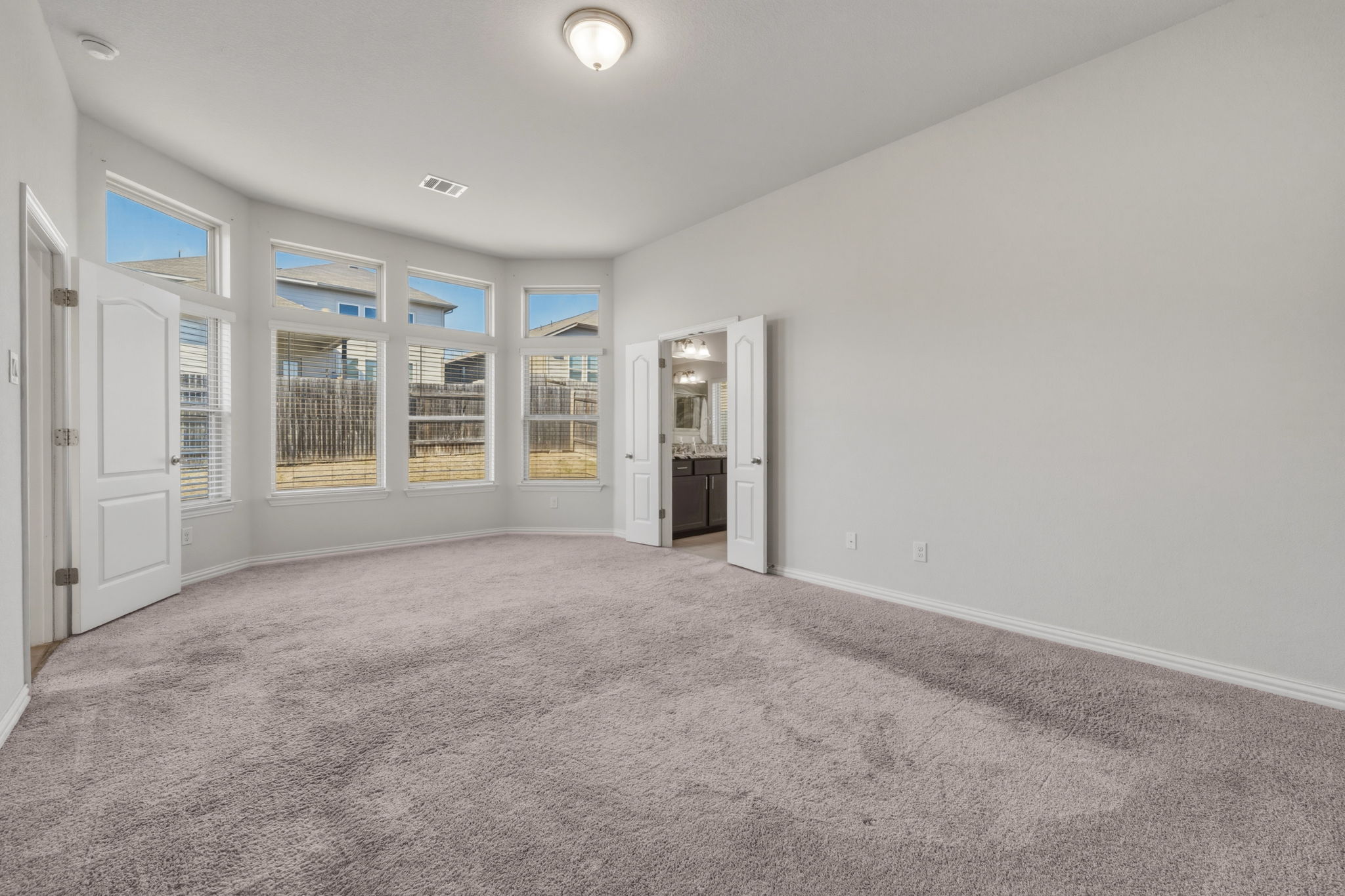 918 Leadtree Loop Buda, TX 78610 - Photo 24 of 27 Unfurnished bedroom with light colored carpet and ensuite bath